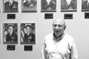 Bruce Telfeyan, a lifelong meteorologist who has spent the last 23 years at the 557th Weather Wing, stands before a wall of past weather commanders in the Wing at Offutt Air Force Base, Neb., Sept. 14, 2015. Throughout his time at the wing, Telfeyan has seen most of these commanders come and go.