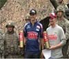 Dale Earnhardt Jr. and Graham Rahal in casual racing clothing standing with men in military uniform