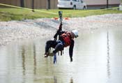 Rescue worker hangs in harness over lake during training exercise