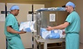 Army Staff Sgt. Oscar Domino (left), operating room technician, hands a sterile pack to Army Maj. Jerry Rivera-Santiago, sterile processing's officer in charge. Carl R. Darnall Army Medical Center's Sterile Processing Department assembles and packs more than 400 surgical units monthly. (U.S. Army photo by Gloria Montgomery)