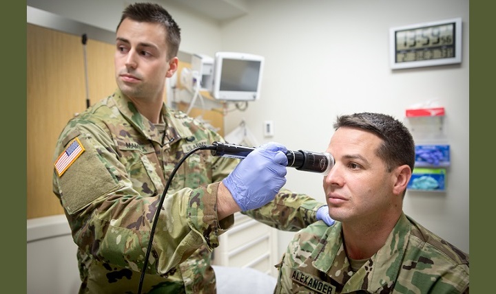 In a demonstration of the telehealth process at Fort Campbell’s Blanchfield Army Community Hospital, clinical staff nurse Army Lt. Maxx P. Mamula examines mock patient Army Master Sgt. Jason H. Alexander using a digital external ocular camera. 