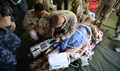 Navy field medical service technicians, along with Navy Health Service Augmentation Program personnel prepare a mock casualty for evacuation. 