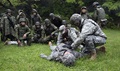 U.S. Army Medical Activity-Japan Soldiers demonstrate part of the bi-lateral tactical combat casualty care training while Japan Ground Self-Defense Force members watch at Camp Zama’s Dewey Park.