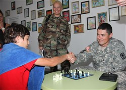 CEADIR-LUNGA, Moldova - Right, U.S. Army Capt. Dave Esra, former firefighter
 and emergency services subject matter expert; the commander of the
 Headquarters and Headquarters Company, 361st CA Bde. and Jackson, Tenn.
 native loses at chess to Cristian Trocin, on left, from Dcochia City,
 Moldova as Moldovan Army Maj. Inga Gorgan, chief of administration section,
 Peacekeeping Center and Chisinau, Moldova native watches at Moldova's
 National Children Rehabilitation Center in Ceadir Lunga, Moldova Sept. 11,
 2013.
