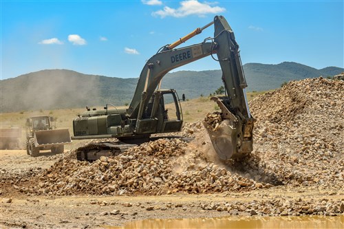 A hydraulic excavator operated by military engineers from the 841st Engineer Battalion, U.S. Army Reserve moves rock near a road under construction on July 6, 2016 at Novo Selo Training Area, Bulgaria during Operation Resolute Castle 2016.  Soldiers from the 841st Engineer Battalion spent the summer of 2016 working with service members from the Tennessee Army National Guard and Mississippi Army National Guard to improve a tank training range and ammunition holding area in Bulgaria.  (U.S. Army photo by Capt. Kimberlee Lewis, 841st Engineer Battalion, U.S. Army Reserve)