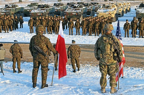 In front of a formation of two allied nations, a Polish and American soldier stand side by side bearing their country’s colors before an opening of training ceremony recognizing the partnership between the two participating units, K Troop, 3rd Squadron, 2nd Cavalry Regiment, and the 12th Mechanized Brigade, Polish Army, Jan. 18, at Konotop, Poland. Following the ceremony, 3-2 Cavalry Soldiers conducted squad-level training alongside Polish allies in support of Atlantic Resolve, a multinational demonstration of continued U.S. commitment to the collective security of North Atlantic Treaty Organization allies. (U.S. Army photo by Sgt. Paige Behringer, 10th Press Camp Headquarters)