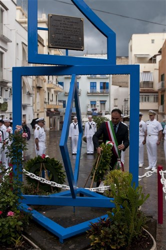 GAETA, Italy - Cosmos Mitrano, mayor of Gaeta, places a wreath on a statue honoring Lt. Vincent Capodanno at Piazza di Capodanno. The ceremony was held on the 45th anniversary of Capodanno's death. 