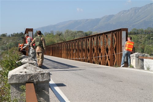 U.S. Army Corps of Engineers, Europe District Forward Engineer Support Team (FEST) members Stan Young (right), civil engineer and Cpt. Richards (left), 7th Civil Support Command, take measurements during a bridge reconnaissance as Italian military officer, First Lieutenant Lasi looks on and secures the area during the training September 18, 2012 in Aviano, Italy.