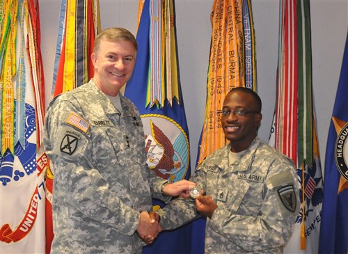 Lt. Gen. William Garrett, EUCOM deputy commander, presents a coin to Staff Sgt. Marvin Hannah, a property management clerk at U.S. European Command's Headquarters Commandant office.