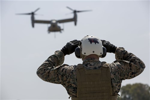 U.S. Marine Corps Lance Cpl. Mackinnly Lewis, a landing support specialist with Combat Logistics Battalion 2, Special Purpose Marine Air-Ground Task Force-Crisis Response-Africa, guides an MV-22B Osprey during a helicopter support team exercise aboard Naval Station Rota, Spain, July 6, 2016. This training prepares Marines to deliver and recover supplies and equipment quickly and efficiently in potential future missions around Europe and Africa. (U.S. Marine Corps photo by Staff Sgt. Tia Nagle/Released)