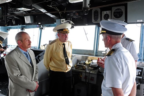 BALTIYSK, Russia - Capt. Kevin Hill, commanding officer of the guided-missile cruiser USS Normandy (CG 60), right, explains the ship's capabilities to Russian navy Rear Adm. Sergei Popov, commander, Naval Base Baltiysk of the Baltic Fleet, center, and Mr. Ivan Ivanovich Cherbin, mayor of Baltiysk, left, during a tour of the ship. Normandy is in Baltiysk to participate in the multinational exercise FRUKUS 2012, FRUKUS is an annual exercise aimed at improving maritime security through an open dialogue and increased training between the navies of France, Russia, United Kingdom and United States. 