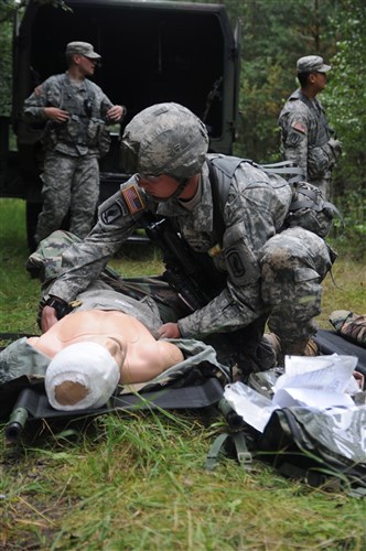 Spc. Bruce Case, Brigade Support Battalion, 173rd Airborne Brigade Combat Team, treats a simulated casualty on Combat Testing Lane 1 during the 2011 U.S. Army Europe Expert Field Medical Badge Standardization and Testing August 1, 2011 in Grafenwoehr, Germany. (Photo by Army Staff Sgt. Thomas Wheeler, 138th PAD, NYARNG)