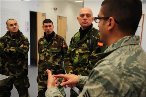 RAMSTEIN AIR BASE, Germany &mdash; U.S. Air Force Senior Airman Victor Camacho, a mission readiness spare package journeyman with the 86th Maintenance Squadron, describes daily operation procedures to members of the Republic of Macedonia Army (RAM). The RAM visit to Ramstein was designed to allow them to see transportation, packing and handling operations in action as well as movements into the theater in support of a deploying or deployed unit so that they may developed a more standardized system to assist them in intergrading their operations with the U.S. and NATO. (U.S. Air Force photo by Staff Sgt. Jocelyn Rich)