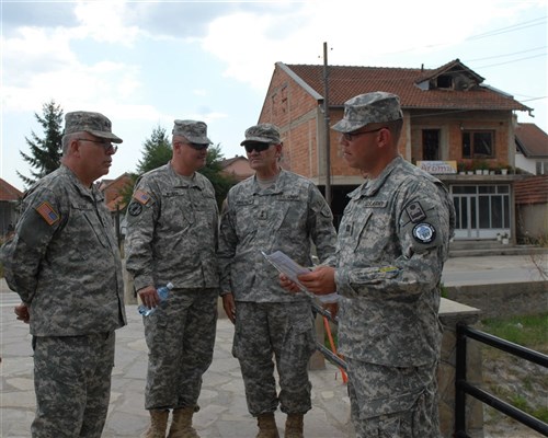 CAMP BONDSTEEL, Kosovo &mdash; Puerto Rican army Maj. Gen. Antonio J. Vicens, adjutant general of the Puerto Rico National Guard, Maj. Gen. David A. Sprynczynatyk, adjutant general of North Dakota National Guard, and Puerto Rican army Col. Francisco J. Neuman, of Ponce, Puerto Rico, commander of Multinational Battle Group East, listen as Puerto Rican army Capt. Angel Lopez, of Guanica, Puerto Rico, officer in charge of Liaison Monitoring Team 5, Multinational Battle Group East explains the history of &#34;Freedom Bridge&#34; during a tour of Viti/Vitina, Kosovo July 24. (U.S. Army photo by Sgt. Joshua Dodds)