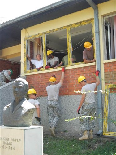 Two U.S. Soldiers, a MEDA-3 contractor and a Macedonian army soldier secure a large window frame into one of the classrooms at Femo Kulakov Kindergarten School in Negotino, Macedonia, as part of a renovation project that began in early August. The 412th Engineer Company out of Scranton, Penn., worked side-by-side with nine Macedonian soldiers and two local contractors. Contractors from the company MEDA-3 provided all 120 frames, 250 windows, 14 doors and on-the-job training to both Macedonian and U.S. Soldiers on the proper installation of the doors and windows. The renovation project was completed Aug. 25 and a dedication ceremony was held Aug. 26, 2014.