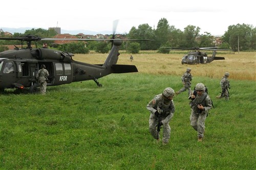 Soldiers from Multinational Battle Group Easttâ?s Bravo Company, 2nd Platoon, move to set up a security perimeter around a helicopter landing site near Viti/Vitina, Kosovo, during quick reaction force exercises June 22.