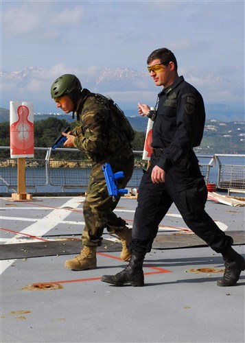 SOUDA BAY, Greece &mdash; NATO Maritime Interdiction Operations Training Center instructor Warrant Officer Niko Bouras (right), guides Spanish Marine Cpl. Daniel Rodriguez Palacios through a simulated firearm exercise during exercise Phoenix Express 2009 here April 28. Phoenix Express is part of the overall U.S. Africa Command and U.S. Naval Forces Europe, U.S. Naval Forces Africa, U.S. 6th Fleet Theatre Security Cooperation strategy to enhance regional stability in the region through increased interoperability and cooperation among regional allies from the United States, Africa and Europe. (Department of Defense photo by Navy Mass Communication Specialist 1st Class Jenniffer Rivera)