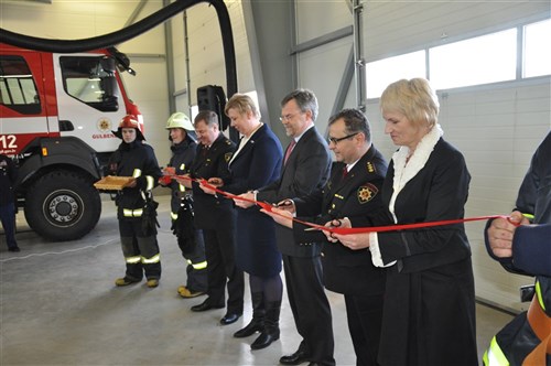 The local firemen hold the ribbon while (left to right) Vijars Grikis(Commander of Gulbene fire station); Mrs. Ilze Petersone-Godmane (State Secretary of the Ministry of Interior); U.S. Ambassador Mark Pekala; COL Intars Zitans (Deputy Chief of the State Fire and Rescue Service) and Mrs. Sandra Daudzina (Mayor of the Gulbene region) officially open the new three-bay fire station garage in Gulbene, Latvia that will provide facilities for the SFRS's new trucks bought with national and EU funds.