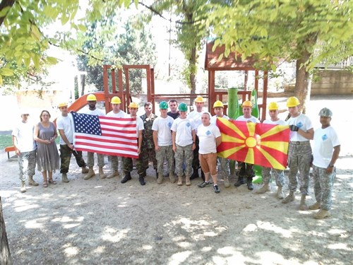 Engineers from the United States and Macedonia hold their respective countries flags together in partnership in Negotino, Macedonia. The 412th Engineer Company out of Scranton, Penn., began renovation of the Femo Kulakov Kindergarten in early August. They worked side-by-side with nine Macedonian soldiers and two local contractors. The contractors from the company MEDA-3 provided all 120 frames, 250 windows, 14 doors, and on-the-job training to both Macedonian and U.S. Soldiers on the proper installation of the doors and windows. The renovation project was completed Aug. 25, and a dedication ceremony was held Aug. 26, 2014.