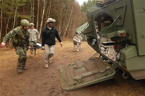 GRAFENWOEHR, Germany &mdash; Staff Sgt. Martin Teresica, a medic with the Armed Forces of the Slovak Republic, evacuates a simulated &#34;patient&#34; on a litter to a Stryker armored vehicle with the help of U.S. Army Europe soldiers serving as support staff for the 2009 U.S. Army Europe Expert Field Medical Badge Competition at the training area here, March 26. Teresica and 15 other partner nation participants from five European countries have been training and competing alongside more than 230 USAREUR medical personnel during the competition that concludes March 30. (Department of Defense photo)