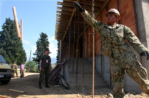 A U.S. Navy Seabee tosses planks of wood into a pile during the renovation process of Bijelo-Potoci Primary School in Mostar, Bosnia and Herzegovina May 31. Seventeen Navy Seabees deployed to Capljina and members of the Bosnia and Herzegovina military are working together to renovate schools in the area in support of Exercise Shared Resilience 2012, a two-week U.S. Joint Chiefs of Staff sponsored medical exercise.