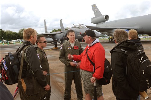 RAF FAIRFORD, United Kingdom - Ian Warner, of Sharnford, Leicestershire, talks with Maj. Jon Lee and 1st Lt. Adam Thompson, 494th Fighter Squadron, about squadron patches during the Royal International Air Tattoo at RAF Fairford. Lee and Thompson flew an F-15E Strike Eagle from RAF Lakenheath to display during RIAT. 