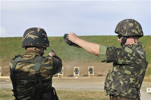 CAMP BONDSTEEL, Kosovo &mdash; A soldier from the Ukraine contingent, Multinational Battle Group East, catches the shell casing fired by a Soldier from the Greek contingent of Multinational Battle Group East, from the Ukraine Pistolet Makarovo 9mm semi-automatic pistol during the Commander&#39;s Cup shooting competition held at Camp Bondsteel, Kosovo, May 30. (U.S. Army photo by Staff Sgt. Jill Fischer)
