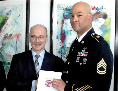 Sgt. 1st Class Jeffrey Guyot holds a letter of appreciation presented to him on behalf of the Wiesbaden Citizens and Polizei Association by Robert Schaefer, West Hessen police president, April 3, 2012, for his assistance in a hit-and-run incident.