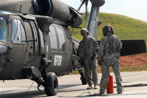 CAMP BONDSTEEL, Kosovo &mdash; Army Spc. Tyson Brian (left), Des Moines, Iowa, a petroleum supply specialist attached to Headquarters and Headquarters Company, 1-114th Aviation Battalion, performs a &#34;hot refuel&#34; on a UH-60 Blackhawk helicopter at Camp Bondsteel, Aug. 2. A &#34;hot refuel&#34; is when a helicopter is refueled with the engines and blades still running. Brian is deployed with the 1-114th as a part of Multinational Battle Group East in support of the NATO peacekeeping mission in Kosovo. (U.S. Army photo by Sgt. Jerry Boffen)