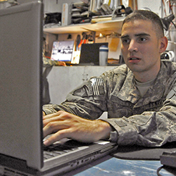 Service member typing on a laptop