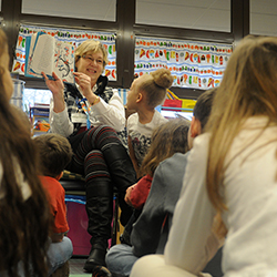 Teacher showing book to group of students.