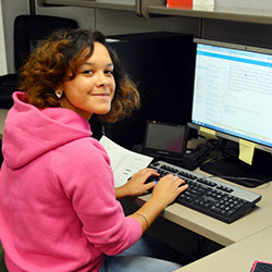 Teen girl sitting typing on a computer