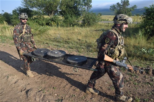 Hungarian Soldiers carry a weighted casualty litter to help elevate their heartrate before engaging targets during a stress shoot at Camp Ujamajor, Hungary July 13, 2016. The Troopers are in Hungary as a part of Operation Atlantic Resolve, a demonstration of continued U.S. commitment to the collective defense of Europe through a series of actions designed to reassure NATO allies and partners of our dedication to enduring peace and stability in the region.