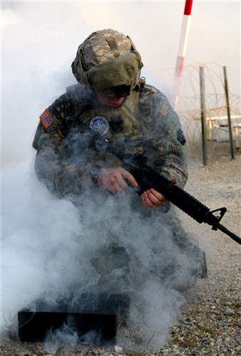 Sgt. Andrew Couchenour, an intelligence NCO and Pennsylvania Army National Guardsman deployed to Kosovo with the 2nd Infantry Brigade Combat Team, 28th Infantry Division, assembles an M4 rifle, while a thick cloud of smoke limits his visibility during the stress shoot portion of the Multinational Battle Group-East's Best Warrior Competition held on Camp Bondsteel, Kosovo, July 10. (U.S. Army photo by: Staff Sgt. Thomas Duval, Multinational Battle Group-East public affairs)