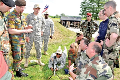 Spc. Daniel Donaldson (standing, third from left) and Sgt. Mohammed Echiheb (behind machine gun) describe the operation of an M249 squad automatic weapon at one of the stations at the Monte Kali shooting competition in Wackernheim.