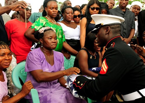 United States Marine Corps Corporal Michael Wiles, of Willingboro, N.J., presents a flag to Famata Kar, mother of fellow U.S. Marine and best friend, Lance Corporal Abraham Tarwoe, of Providence, R.I., at a memorial service in Flehla, Liberia, May 17. Tarwoe, who was born in Liberia but immigrated to the United States prior to joining the U.S. Marine Corps, died from wounds suffered in combat in Helmand province, Afghanistan, April 12. Wiles was assigned by the Marine Corps to escort Tarwoe&#39;s body back to Liberia for burial. At the time of his death, Tarwoe was deployed from 2nd Battalion, 9th Marine Regiment, Camp Lejeune, N.C. Wiles is stationed with 2nd Marine Special Operations Battalion, Camp Lejeune, N.C.