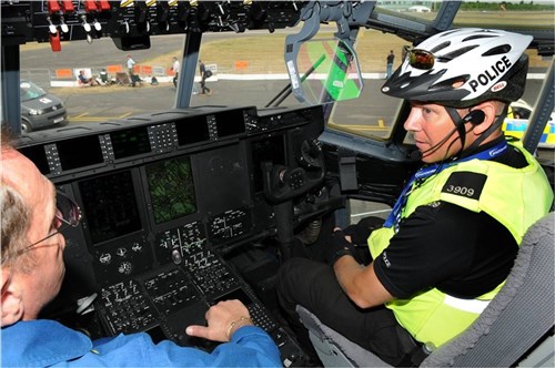 FARNBOROUGH, United Kingdom  â? Carey Depew, Lockheed Martin flight engineer, discusses features in the cockpit of a C-130J Super Hercules with Richard Baldwin, Hampshire police constable, at the 2010 Farnborough International Air Show July 20. The air show takes place July 19-25 with approximately 1300 exhibitors from private, commercial civil and military sectors, 132,000 trade visitors and nearly 153,000 public visitors. (U.S. Air Force photo by Staff Sgt. Heather M. Norris)