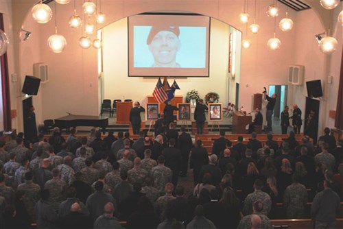 STUTTGART, Germany &mdash; Family, friends and battle buddies of Chief Warrant Officer 3 Gary M. Farwell, Chief Warrant Officer 2 Clayton M. Hickman and Cpl. Matthew E. Clark render final honors while a slideshow of photos depicting the men&#39;s lives plays in the background during a memorial ceremony held at the Panzer Kaserne Community Chapel here, Feb. 11. The soldiers lost their lives in the crash of a UH-60 Blackhawk helicopter during an evening training mission northeast of Manheim, Germany, Feb. 3. All of the men were assigned to G Company, 52nd Regiment, 1st Battalion, 214th Aviation Regiment, 12th Combat Aviation Brigade. (U.S. Army photo by Sgt. Anna K. Perry)