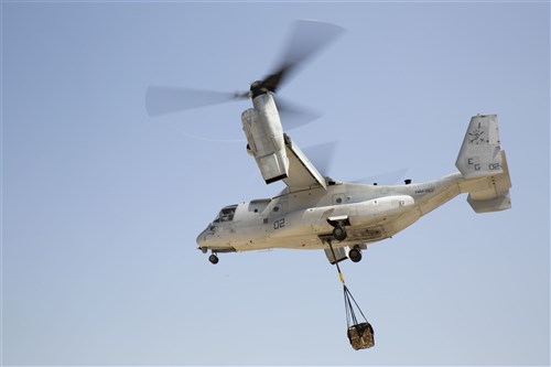 An MV-22 Osprey with Marine Medium Tiltrotor Squadron 263, Special Purpose Marine Air-Ground Task Force-Crisis Response-Africa, transports a 1,098 pound pallet of Meals, Ready to Eat during a helicopter support team exercise aboard Naval Station Rota, Spain, July 6, 2016. External lift training prepares the Marines to efficiently attach cargo to the aircraft and helps qualify air crew in the mission-essential task of rapid insertion and extraction in a possible crisis response scenario. (U.S. Marine Corps photo by Staff Sgt. Tia Nagle/Released)