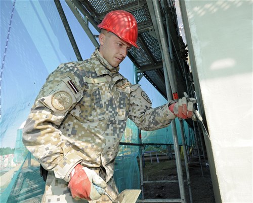 Private First Class Rihards Rudzitis, Latvian National Armed Forces, works on the side of a kindergarten building in Silmala, Latvia on June 19, 2016. The school is undergoing construction as part of the U.S. European Command’s Humanitarian Civic-Assistance project. United States and Latvian military engineers are working together to complete the project. (U.S. Air National Guard photo by Senior Airman Ryan Zeski)