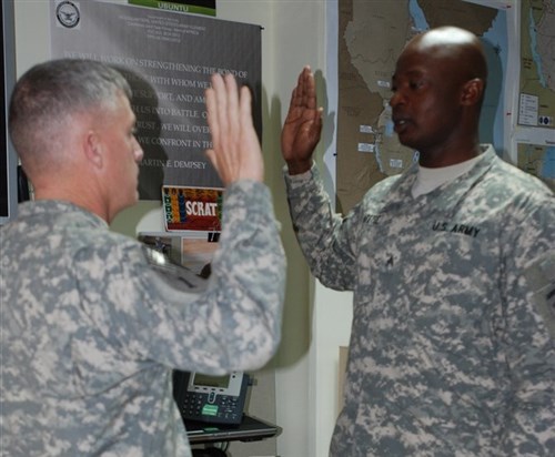 U.S. Army Maj. Gen. Wayne W. Grigsby, Jr., Combined Joint Task Force-Horn of Africa Commanding General, administers the officer’s oath to 2nd Lt. Komi Afetse, a U.S. Army Civil Affairs and Psychological Operations Command Soldier deployed to CJTF-HOA, during a ceremony at Camp Lemonnier, Djibouti, Feb 14, 2015. Afetse immigrated to the U.S. from Togo and received his commission through the U.S. Army Reserve Officer Accession program, or direct commission (courtesy photo)