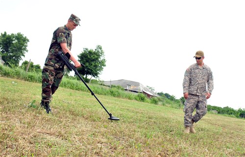 A Moldovan engineer trains with a member of NCNG’s 430th EOD Company in proper metal detector techniques during area clearance. For three weeks, Moldovan and NCNG Soldiers conducted HMA training consisting of reconnaissance, personal and infrastructure protection, minefield safety and individual and team battle area clearance procedures.
