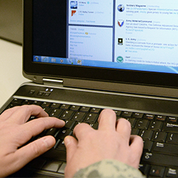 Service member typing on a computer keyboard