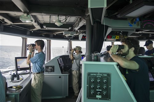 GULF OF GUINEA (April 2, 2014) - Civil service mariners aboard joint, high-speed vessel USNS Spearhead (JHSV 1) look through binoculars at a suspected illegal fishing vessel as part of a U.S.-Ghana combined maritime law enforcement operation under the African Maritime Law Enforcement Partnership (AMLEP) program. AMLEP, the operational phase of Africa Partnership Station (APS), brings together U.S. Navy, U.S. Coastguard, and respective Africa partner maritime forces to actively patrol that partner's territorial waters and economic exclusion zone with the goal of intercepting vessels that may have been involved in illicit activity. Spearhead, the U.S. Navy's first-in-class joint, high-speed vessel, is on its maiden deployment supporting APS in the U.S. 6th Fleet area of operations. (U.S. Navy photo by Mass Communication Specialist Seaman Justin R. DiNiro/ Released)