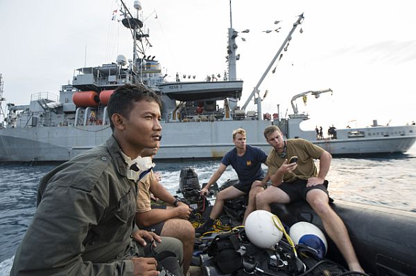 BANTEN BAY (Oct. 20, 2015) Navy Divers assigned to Explosive Ordnance Disposal Mobile Unit 11, Mobile Diving Salvage (MDS) 11-7, and an Indonesian Navy diver prepare for dive operations held in support of search and survey operations of the sunken World War II navy vessels USS Houston (CA 30) and HMAS Perth (D29). The data collected by the dive exercise will help the U.S. embassy in Indonesia and Naval Historical Heritage Command catalog the current state of the wrecks. U.S. Navy photo by Mass Communication Specialist 2nd Class Arthurgwain L. Marquez.