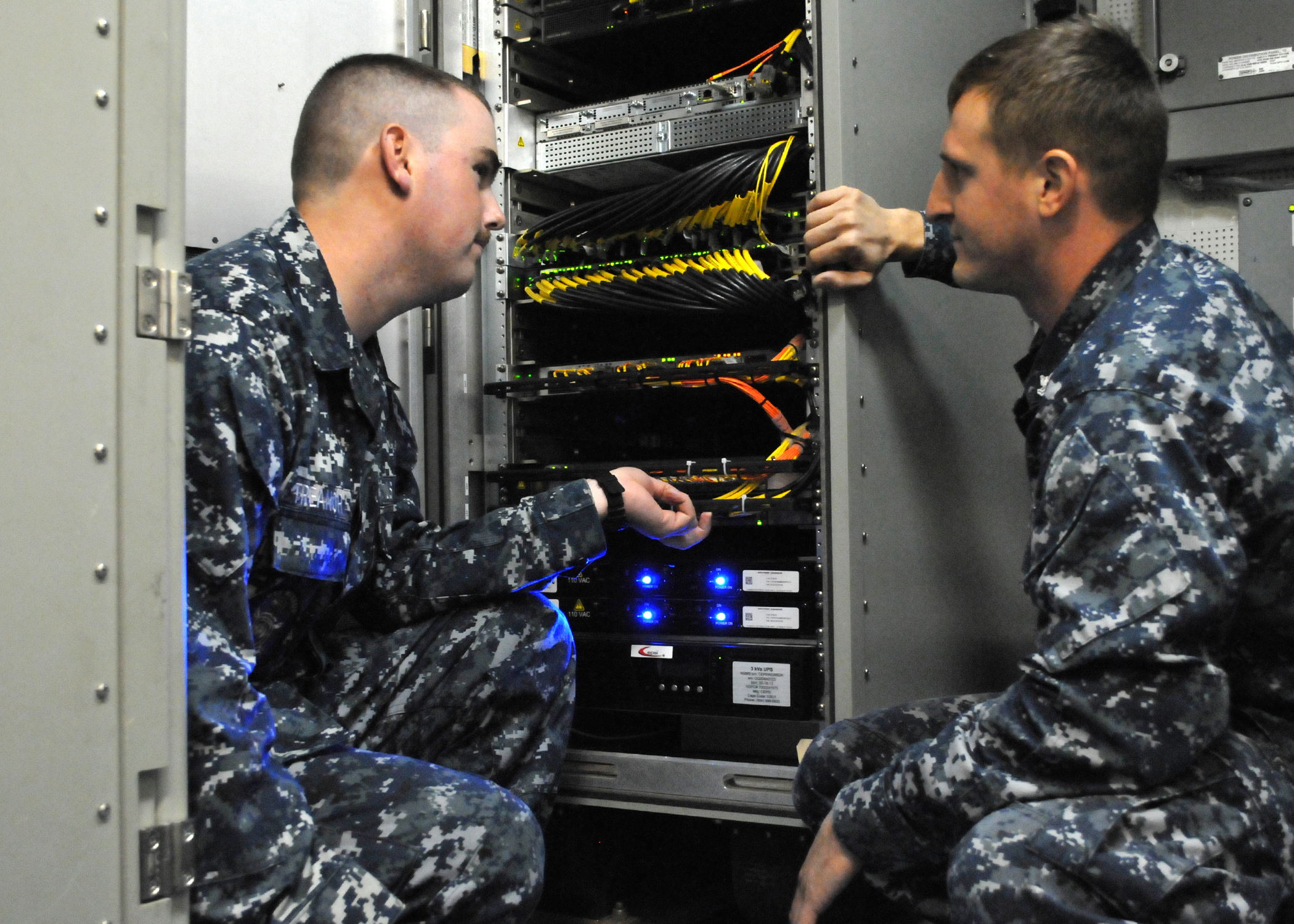 SAN DIEGO (Nov. 19, 2013) Information Systems Technician 2nd Class Anthony Pisciotto, right, familiarizes Information Systems Technician  Seaman Cameron Treanor with the  Consolidated Afloat Ships Network Enterprise Services (CANES) system in the Local Area Network (LAN) Equipment Room aboard the guided missile destroyer USS Milius (DDG 69).  CANES, the Navy's next generation tactical afloat, was recently installed aboard Milius. U.S. Navy photo by Rick Naystatt.