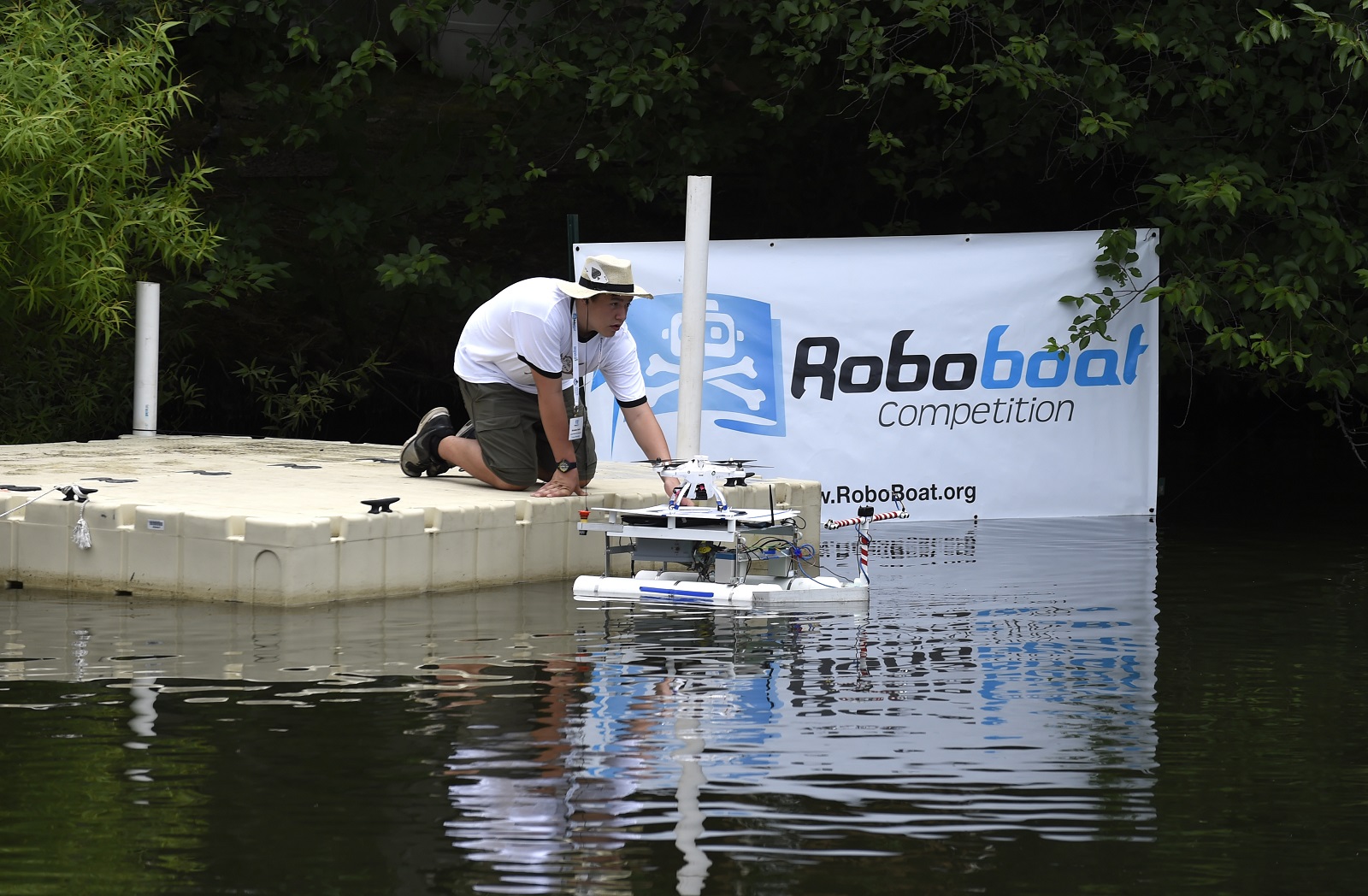 Nick Serle, 15, part of the Daytona Beach Homeschoolers team, launches their autonomous surface vehicle, named the S.S. Minnow,  during the 2015 AUVSI Foundation and Office of Naval Research-sponsored RoboBoat competition held in Virginia Beach, Virginia. U.S. Navy photo by John F. Williams.