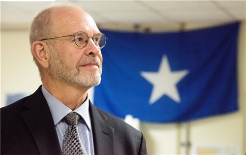 Retired Ambassador David Kaeuper, U.S. Chargé d’Affaires to Somalia stands before the Somali flag during his tour of the Fusion Action Cell hive at Camp Lemonnier, Djibouti, Oct. 15, 2015. The Ambassador toured Combined Joint Task Force-Horn of Africa’s facilities and met with members to learn about the CJTF-HOA mission and its capabilities. (U.S. Air Force photo by Staff Sgt. Victoria Sneed/Released) 