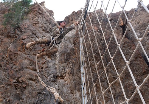  U.S. Army Spc. Matthew Ibasfalean, 2-124 Infantry Battalion soldier, swings and grabs netting during a French Desert Survival Course near Arta Beach, Djibouti, Jan. 13, 2016. By completing the course, service members earned the desert commando badge as a merit to their endeavors