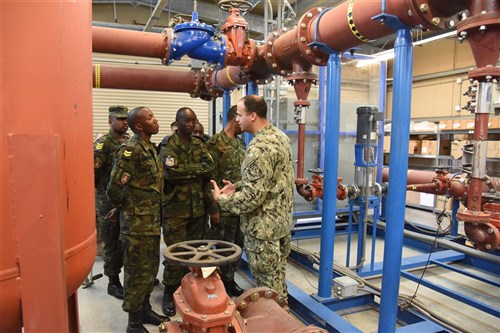 U.S. Navy Lt. Raul Cuevas, Camp Lemonnier Public Works Department civil engineer corps officer, explains the inner workings of the reverse osmosis water purification unit to Rwanda Defence Force engineers at Camp Lemonnier, Djibouti, Feb. 23, 2016. The ROWPU provides clean, drinkable water to the residents of Camp Lemonnier. (U.S. Air Force photo by Staff Sgt. Victoria Sneed)